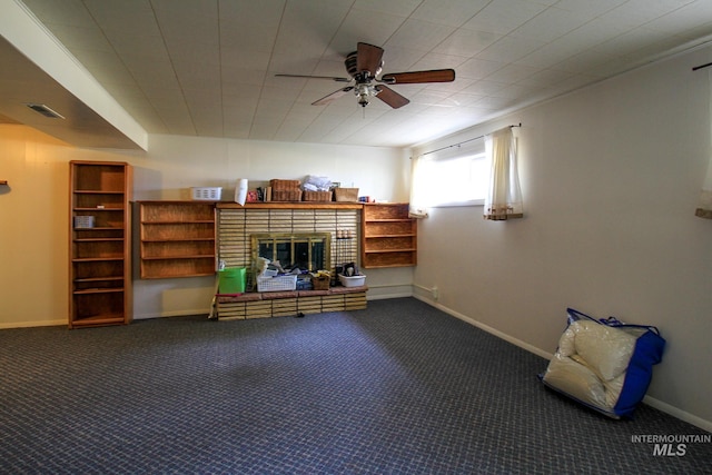 interior space with ceiling fan, carpet floors, and a brick fireplace