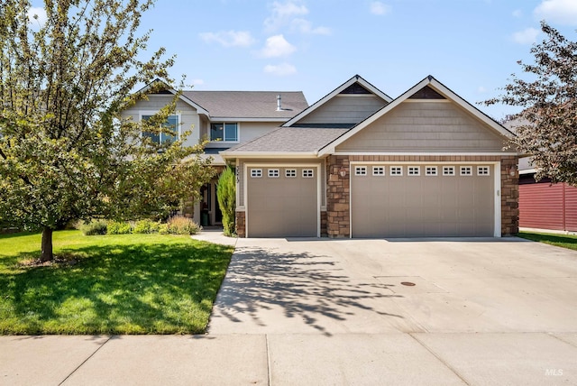 craftsman inspired home featuring a garage and a front lawn