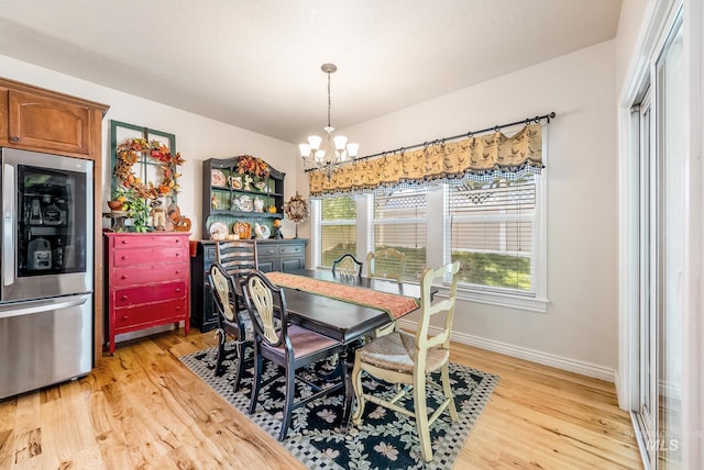 dining space featuring light hardwood / wood-style floors and a notable chandelier