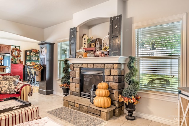 tiled living room featuring a stone fireplace and a wealth of natural light