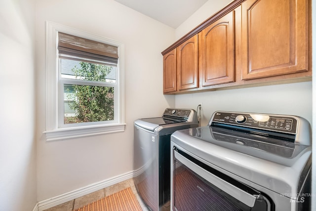 laundry area featuring cabinets, tile patterned flooring, and separate washer and dryer