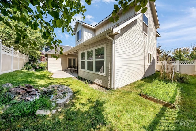 back of property with a patio area and a lawn