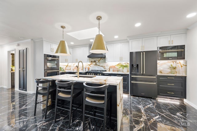 kitchen with white cabinetry, marble finish floor, hanging light fixtures, appliances with stainless steel finishes, and a kitchen bar