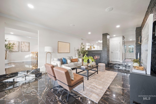 living area with marble finish floor, ornamental molding, a glass covered fireplace, and recessed lighting