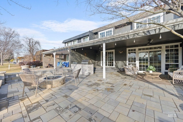 view of patio with a ceiling fan and a fire pit