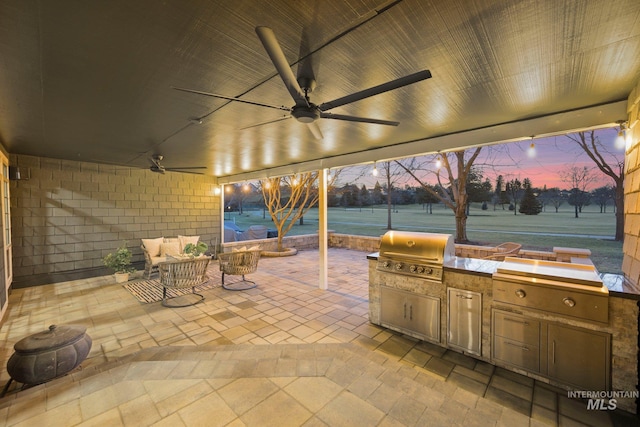 view of patio / terrace with ceiling fan, an outdoor kitchen, and area for grilling