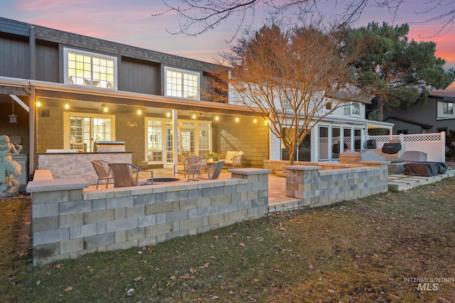 back of property at dusk with a patio