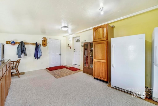 kitchen with light carpet and white refrigerator