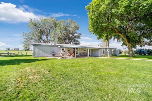 back of house with a patio and a yard