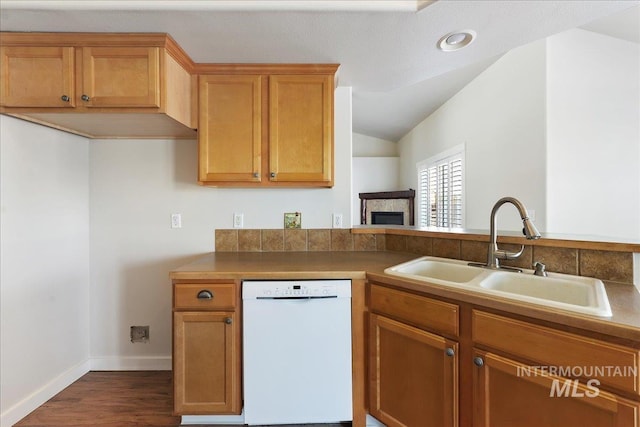 kitchen featuring dark wood-style floors, a fireplace, lofted ceiling, a sink, and dishwasher