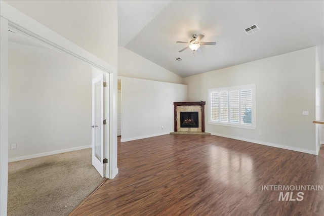 unfurnished living room featuring visible vents, a ceiling fan, a glass covered fireplace, lofted ceiling, and dark wood-style floors