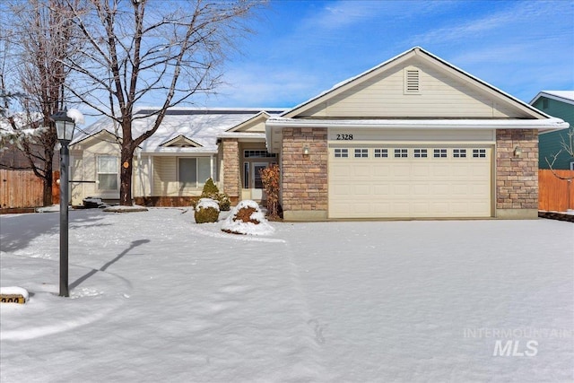 view of front of home with a garage, stone siding, and fence