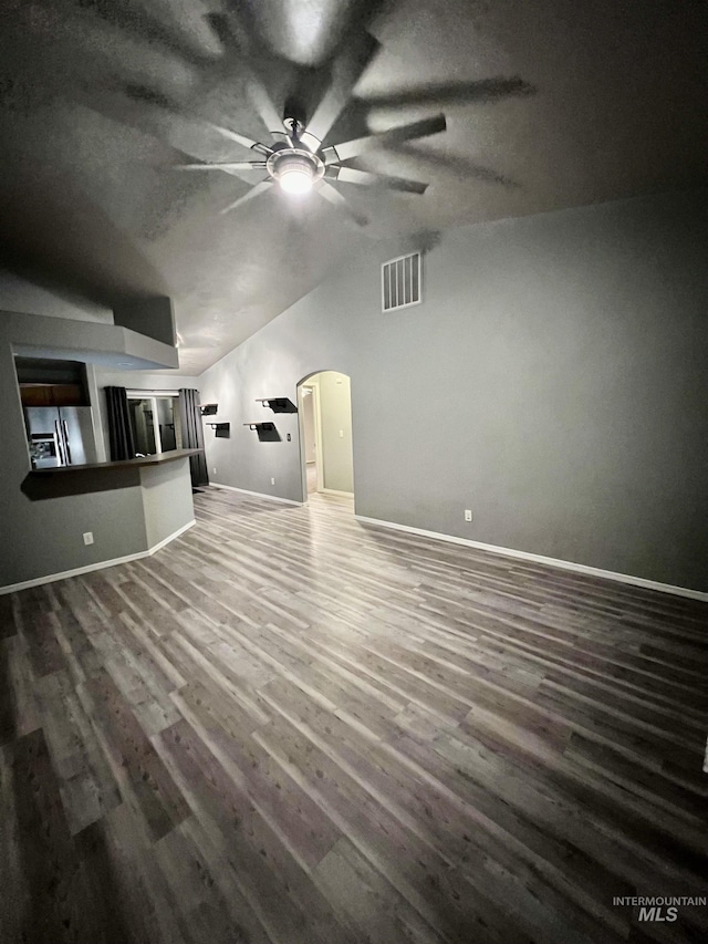 981 SW Independence, Mountain Home, ID 83647 - unfurnished living room with a ceiling fan, visible vents, arched walkways, vaulted ceiling, and wood finished floors