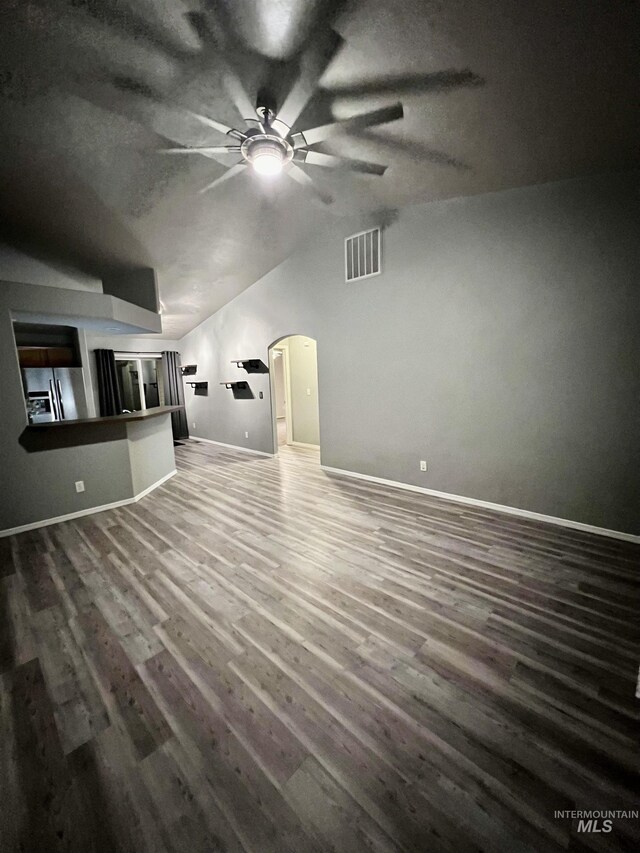 981 SW Independence, Mountain Home, ID 83647 - unfurnished living room with a ceiling fan, visible vents, arched walkways, vaulted ceiling, and wood finished floors