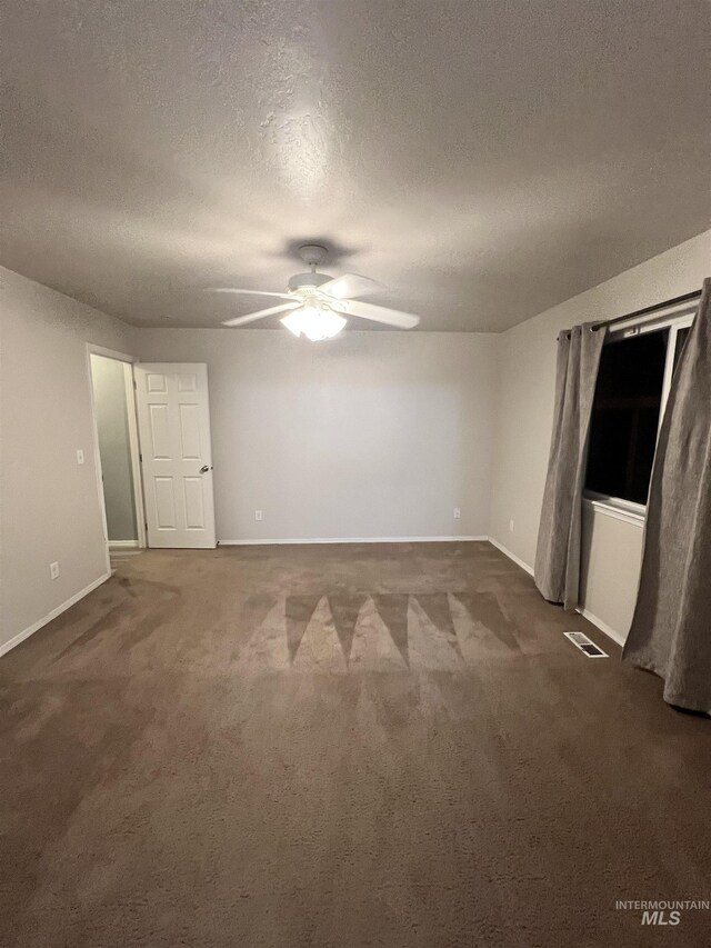 981 SW Independence, Mountain Home, ID 83647 - spare room with visible vents, a textured ceiling, ceiling fan, and dark colored carpet