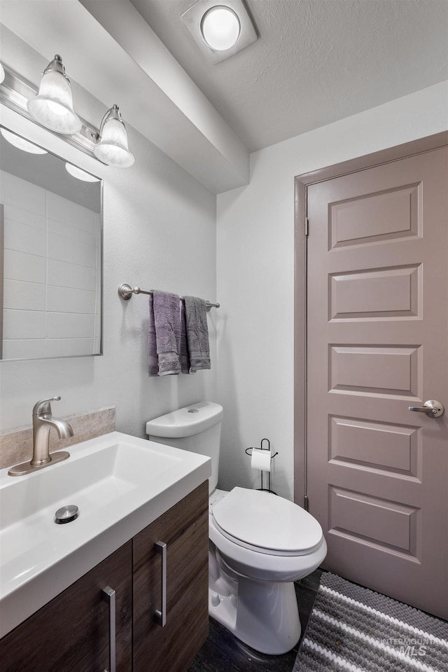 946 S Curtis Rd, Boise, ID 83705 - half bathroom featuring vanity, toilet, and a textured ceiling