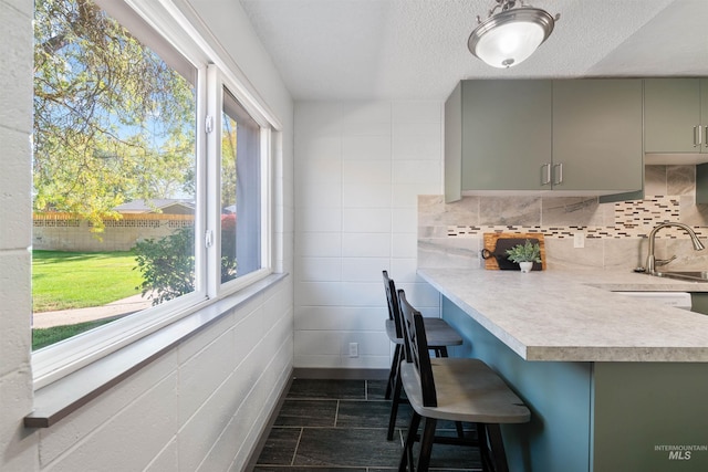 946 S Curtis Rd, Boise, ID 83705 - kitchen with gray cabinets, light countertops, a breakfast bar area, a sink, and a textured ceiling