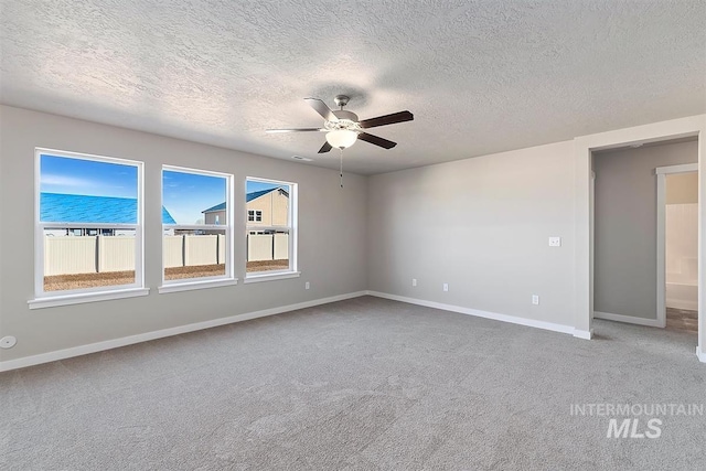 spare room with carpet, ceiling fan, and a textured ceiling