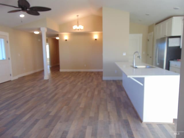 kitchen with lofted ceiling, hanging light fixtures, ceiling fan with notable chandelier, sink, and dark hardwood / wood-style flooring