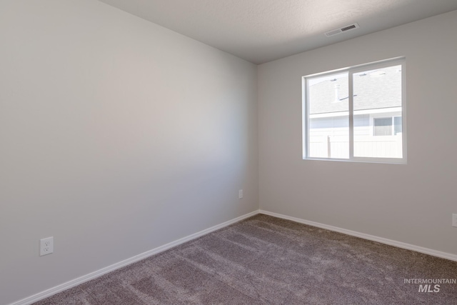 carpeted spare room with a textured ceiling