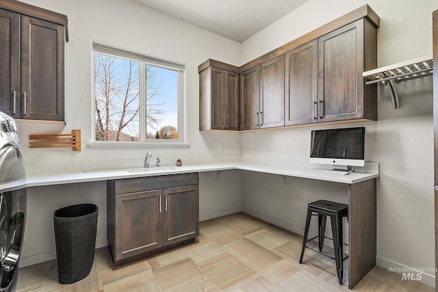 kitchen featuring a kitchen breakfast bar, sink, and dark brown cabinets