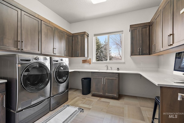 clothes washing area featuring independent washer and dryer, sink, cabinets, and a textured ceiling