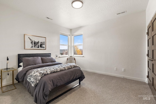 bedroom with light carpet and a textured ceiling