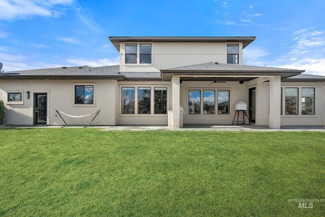 rear view of property with a patio, ceiling fan, and a lawn