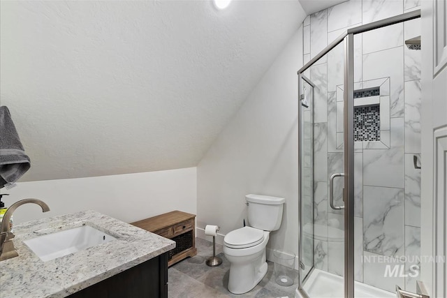 bathroom featuring vanity, vaulted ceiling, a shower with door, and toilet