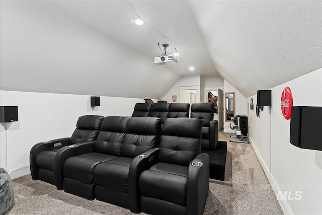 home theater room featuring lofted ceiling, light carpet, and a textured ceiling