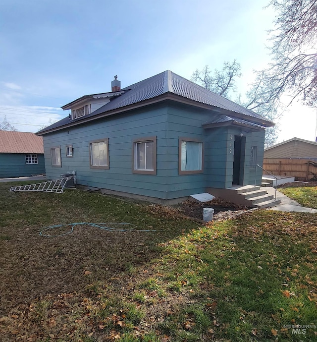 rear view of house featuring a yard