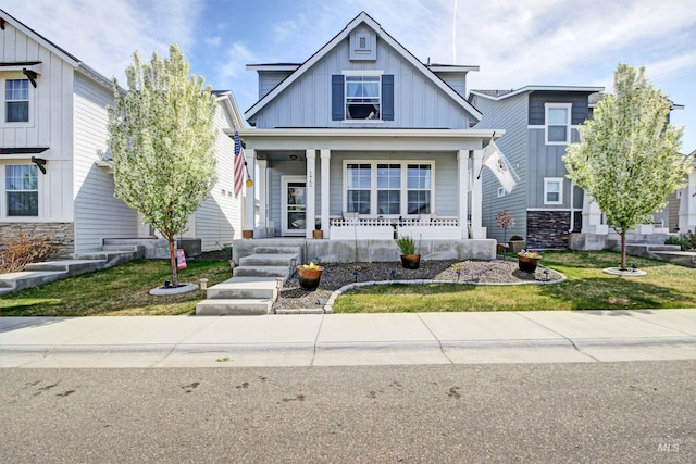 172 S Echo Canyon Ave, Meridian, ID 83642 - view of front of home featuring board and batten siding, a front yard, a porch, and stone siding