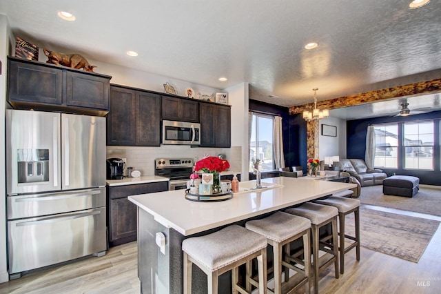 172 S Echo Canyon Ave, Meridian, ID 83642 - kitchen with dark brown cabinetry, plenty of natural light, open floor plan, and appliances with stainless steel finishes