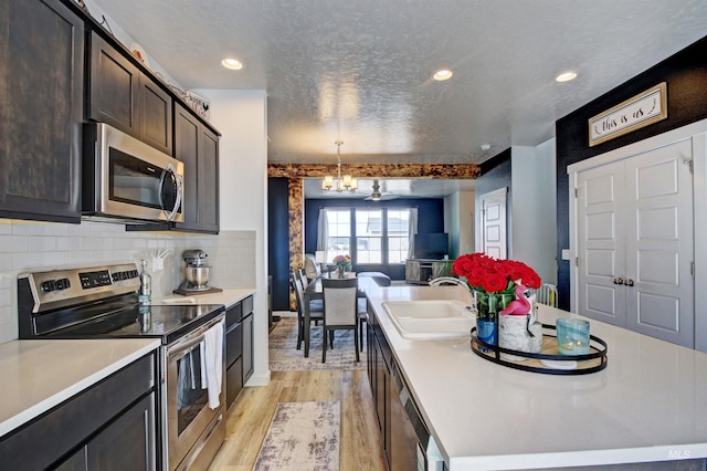 172 S Echo Canyon Ave, Meridian, ID 83642 - kitchen with stainless steel appliances, a sink, open floor plan, light wood-style floors, and an island with sink