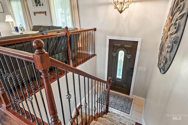 tiled foyer entrance with a notable chandelier