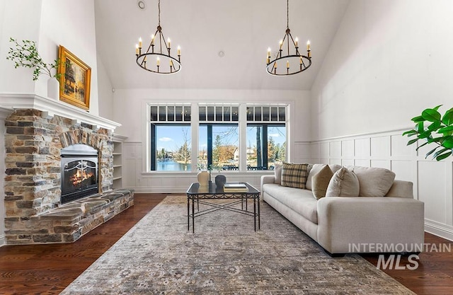 living room with dark wood-type flooring, high vaulted ceiling, and a notable chandelier