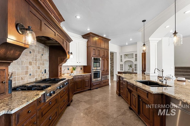 kitchen with sink, appliances with stainless steel finishes, hanging light fixtures, tasteful backsplash, and light stone countertops