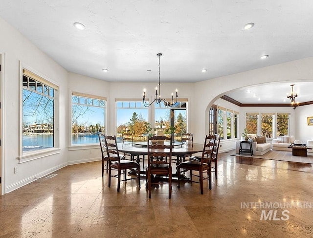 dining room with a water view and an inviting chandelier