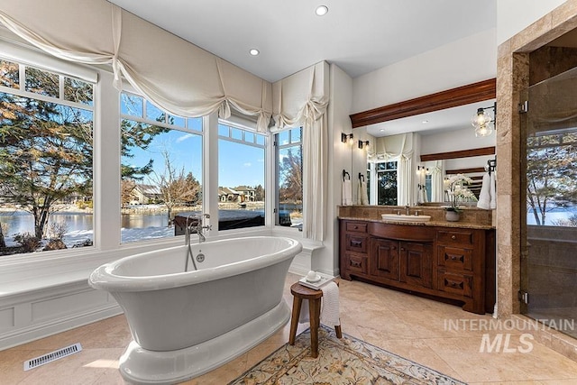 bathroom featuring vanity, tile patterned floors, independent shower and bath, and a water view