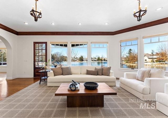 living room with a healthy amount of sunlight, a water view, dark hardwood / wood-style floors, and a notable chandelier