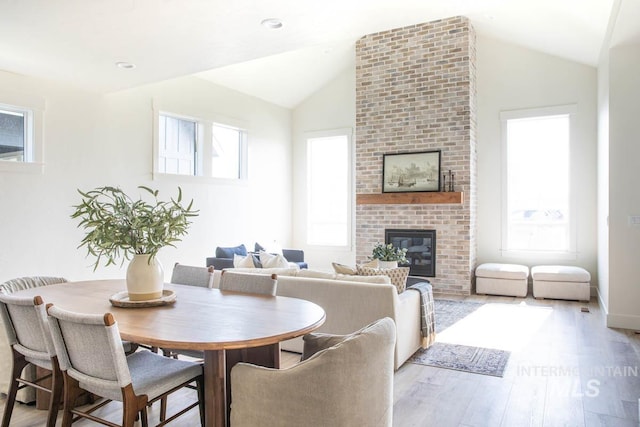6104 S Apex Ave, Meridian, ID 83642 - dining room featuring a fireplace, wood finished floors, and lofted ceiling