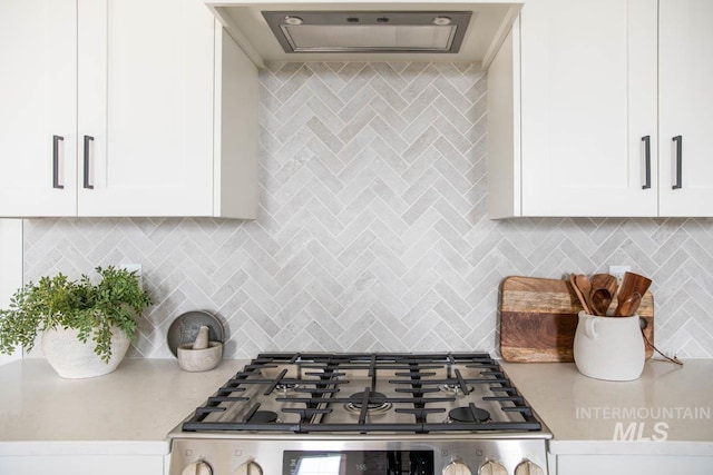 6104 S Apex Ave, Meridian, ID 83642 - kitchen with stove, range hood, white cabinetry, and decorative backsplash