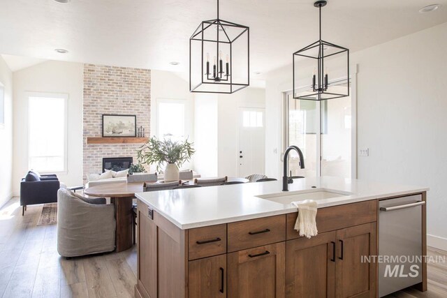 6104 S Apex Ave, Meridian, ID 83642 - kitchen featuring light wood-style flooring, open floor plan, an island with sink, and light countertops