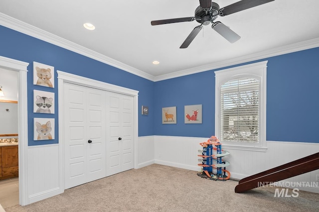 rec room featuring crown molding, light colored carpet, and ceiling fan