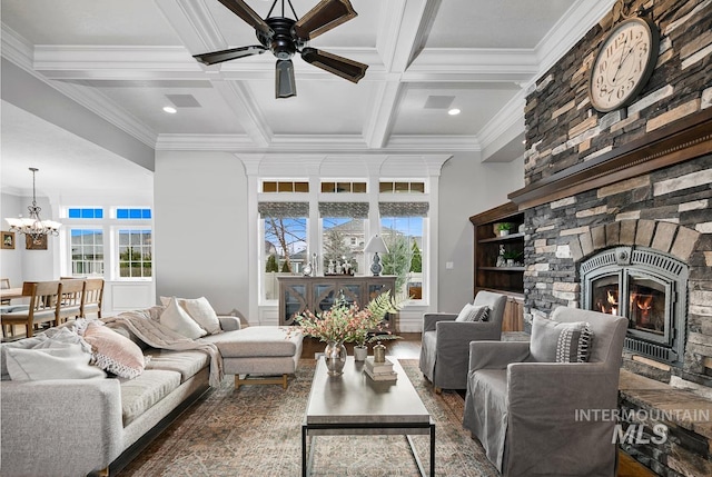 living room featuring coffered ceiling, ceiling fan with notable chandelier, a fireplace, and beam ceiling