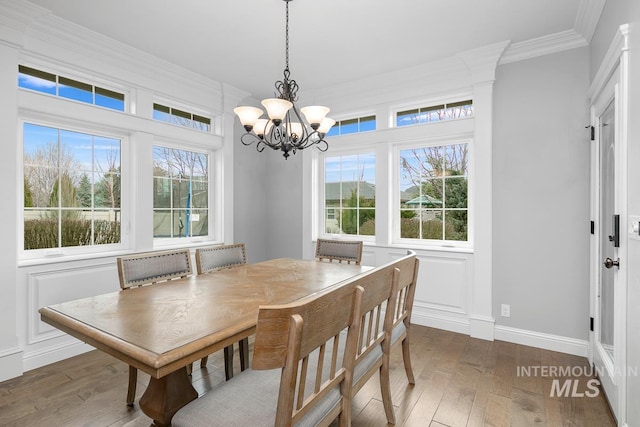 dining room with ornamental molding, dark wood-type flooring, and a chandelier