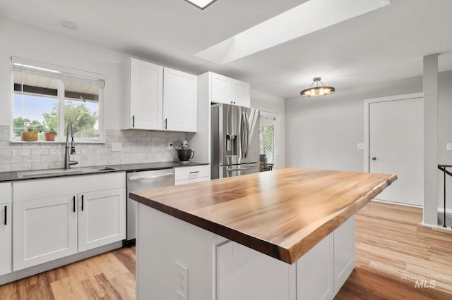 3513 7th St E, Lewiston, ID 83501 - kitchen featuring stainless steel appliances, butcher block countertops, white cabinets, decorative backsplash, and light wood finished floors