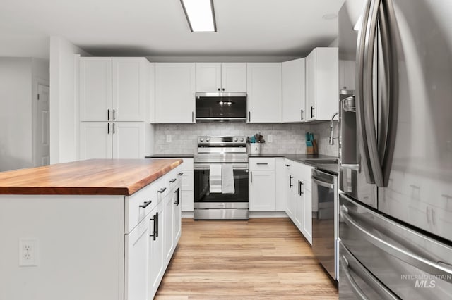 3513 7th St E, Lewiston, ID 83501 - kitchen with stainless steel appliances, butcher block counters, decorative backsplash, light wood-type flooring, and white cabinets