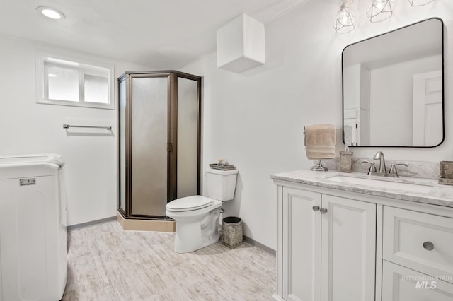 3513 7th St E, Lewiston, ID 83501 - bathroom with washer / clothes dryer, a shower stall, vanity, and wood finished floors