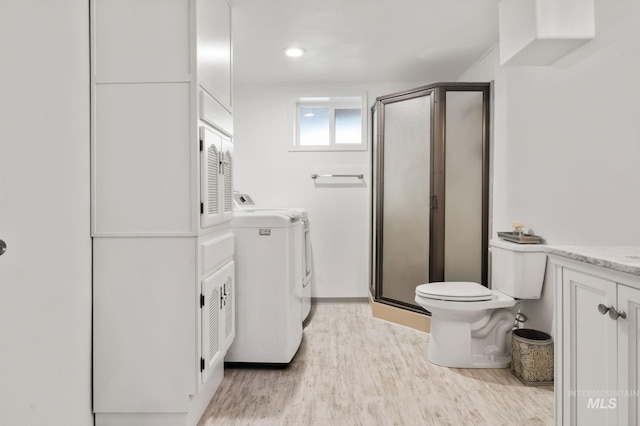 3513 7th St E, Lewiston, ID 83501 - bathroom featuring washer and dryer, a stall shower, wood finished floors, and vanity